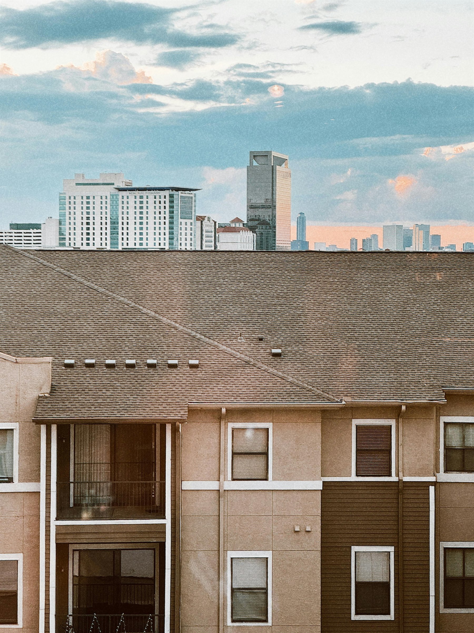 Houston skyline above quiet neighborhood rooftops for the baby Texas state guide.